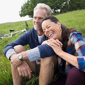 Middle-aged woman sitting next man on a grassy field