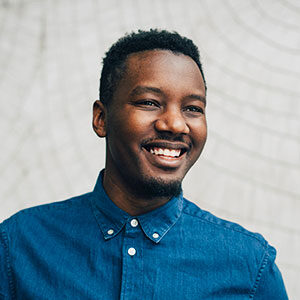 Smiling man in blue shirt looking off to his left