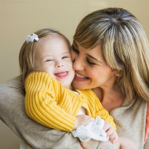 Smiling woman holding child with special needs