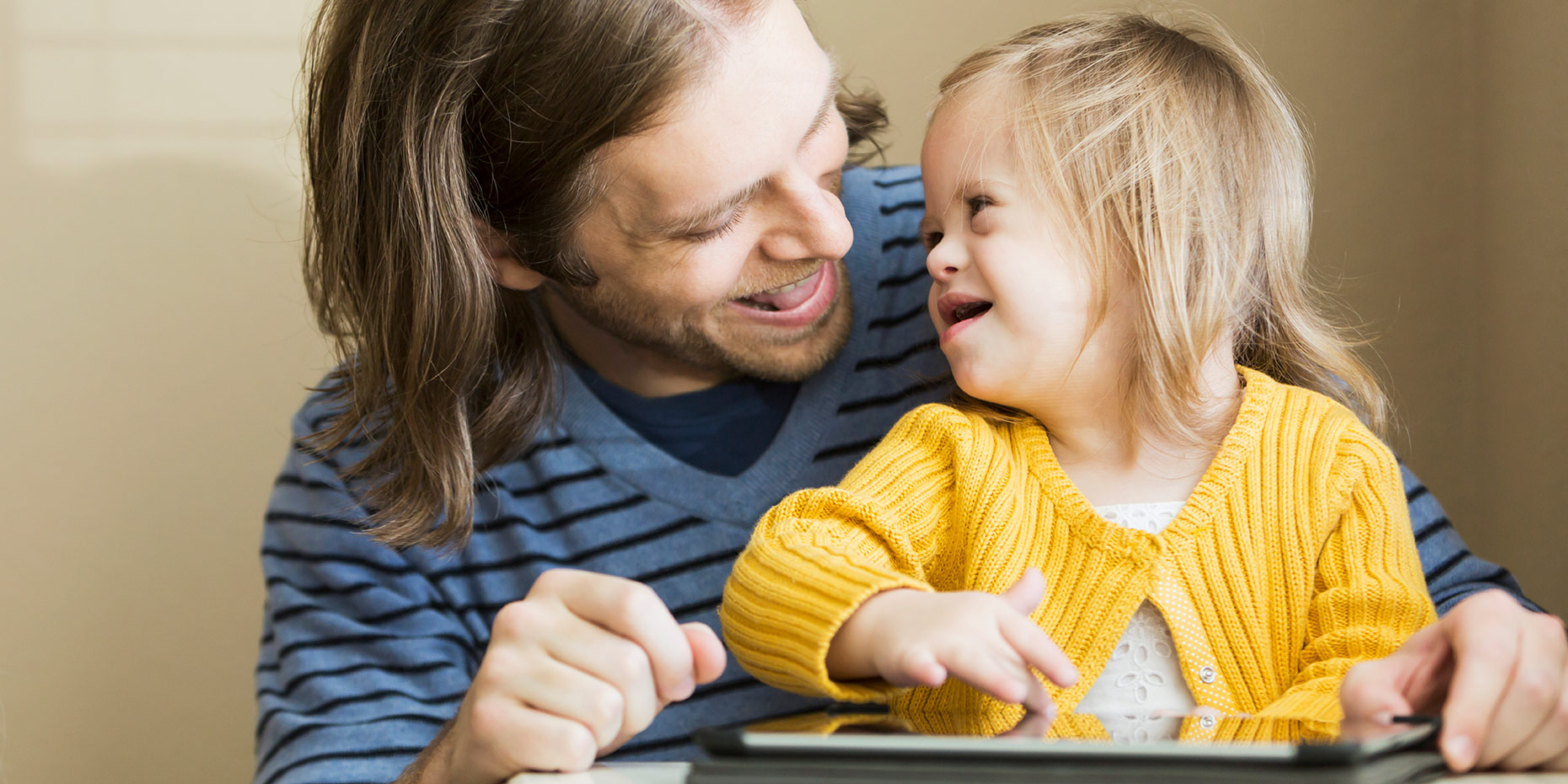 Father and daughter with down syndrome looking at each other smiling