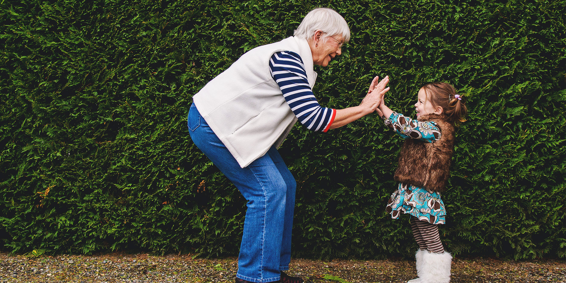 Grandmother high fiving a small child both smiling