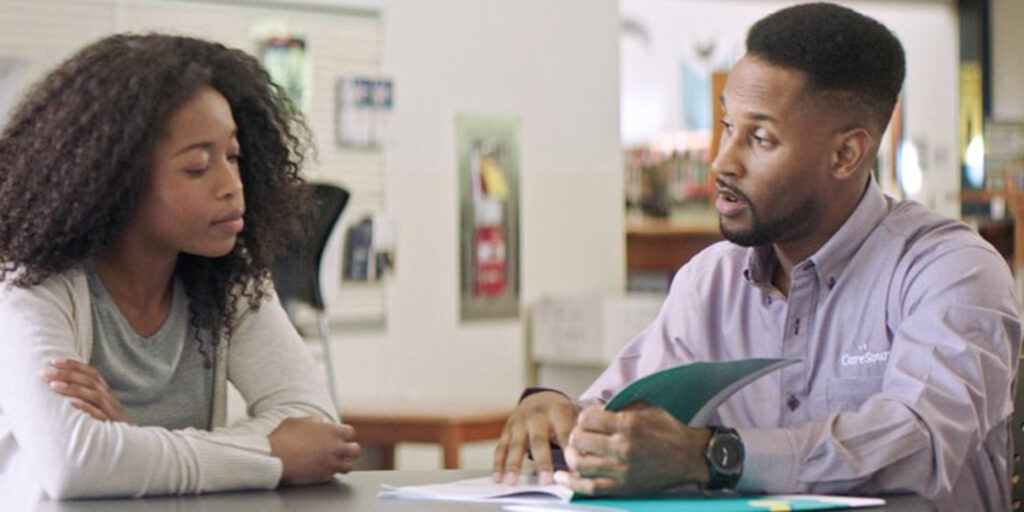 Care Source Care Manager with Member looking at at papers on a table and talking