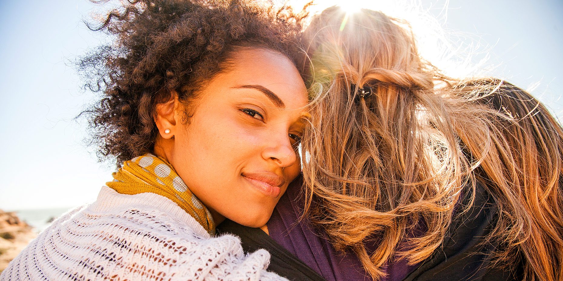 Two women hugging one looking at the camera smiling