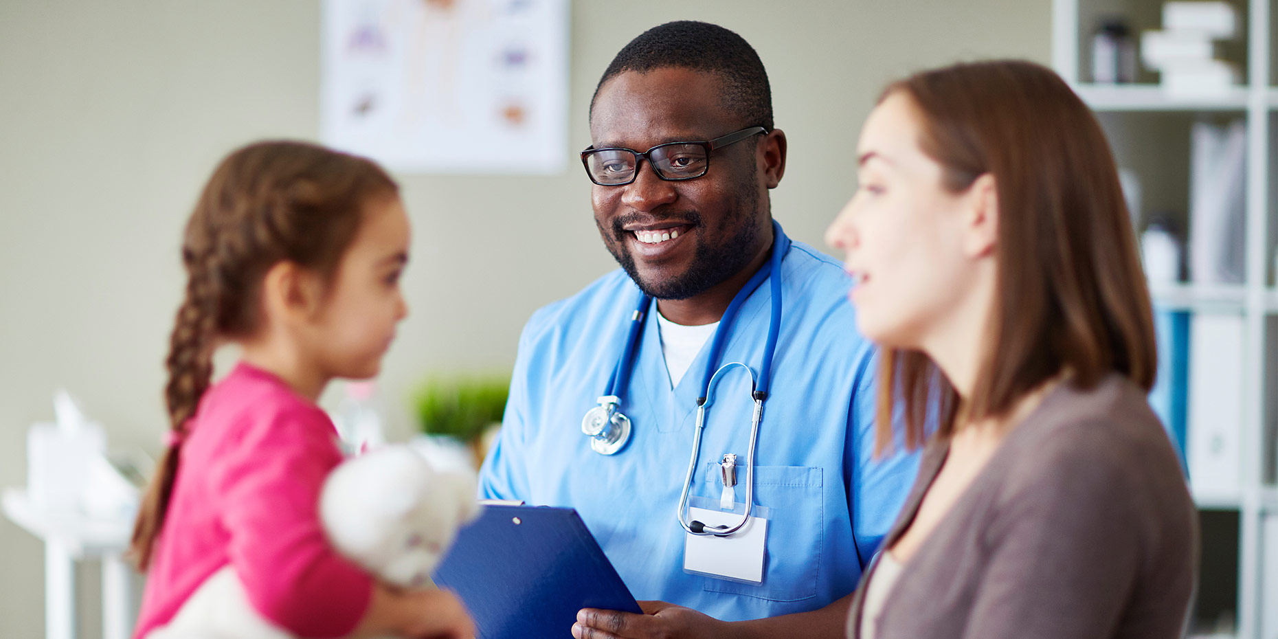Doctor looking at child patient and mother