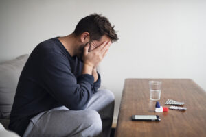 Man sitting at a table filled with drugs