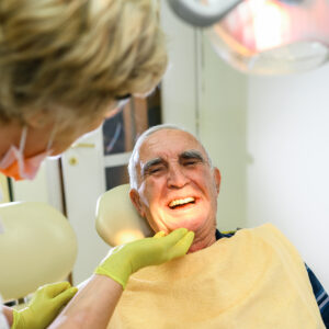 Dentist showing teeth dentures to a senior patient
