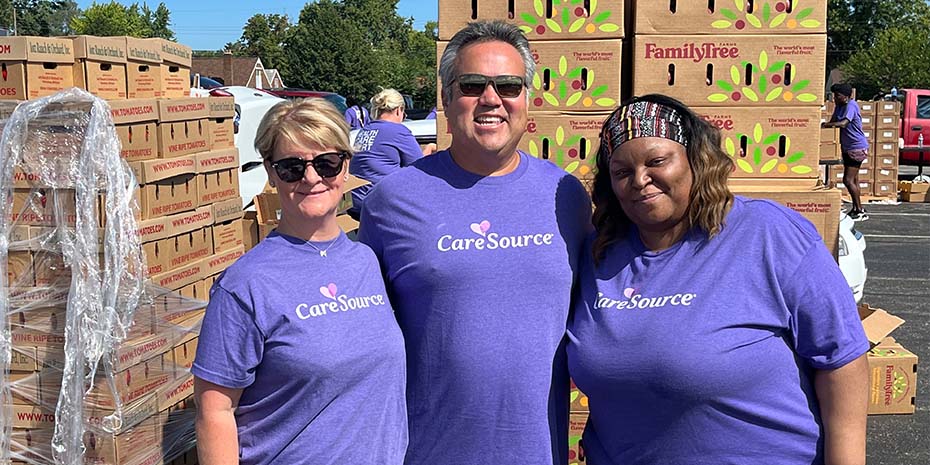 Two CareSource staff stand with Erhardt Preitauer