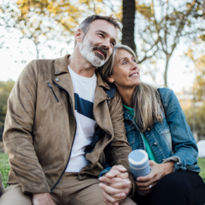 portrait of a mature couple sitting on a bench in a park
